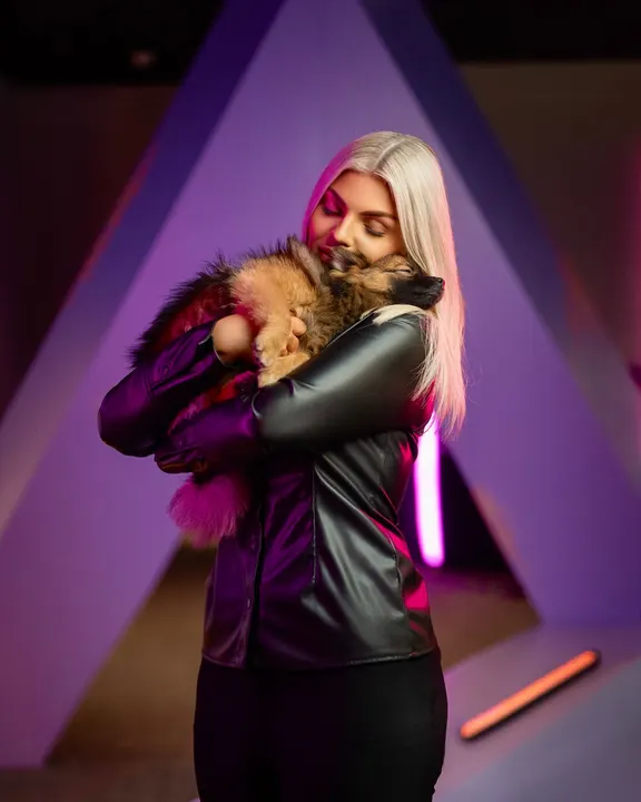 An Adway team member hugging a puppy in front of the A sculpture