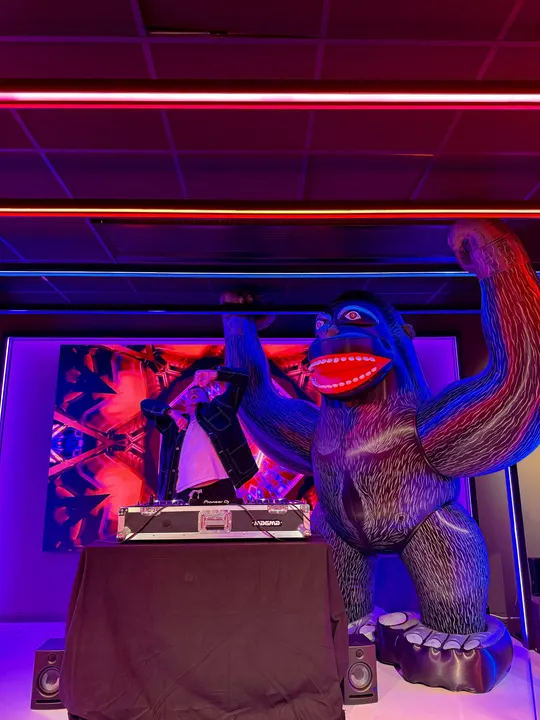 A DJ next to a giant inflatable gorilla at an Adway office party