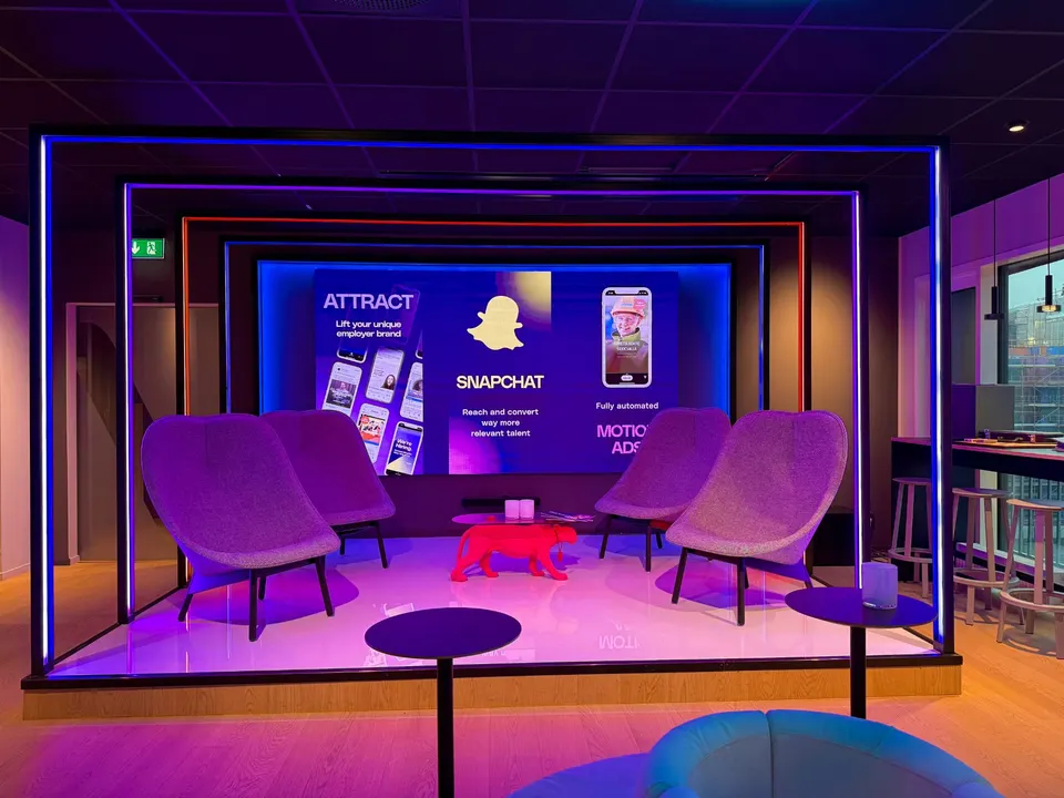 The Adway office stage with lounge chairs and a large screen
