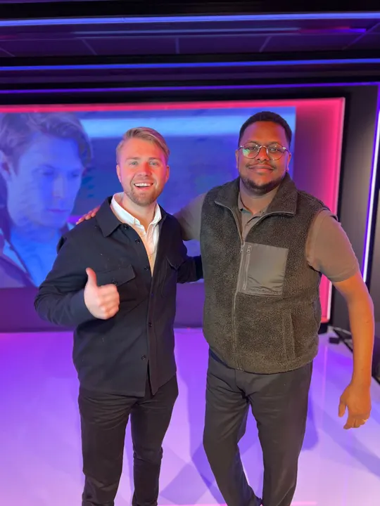 Two Adway team members giving a thumbs up on the office stage