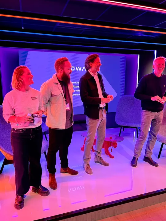 Speakers laughing together on the Adway office stage
