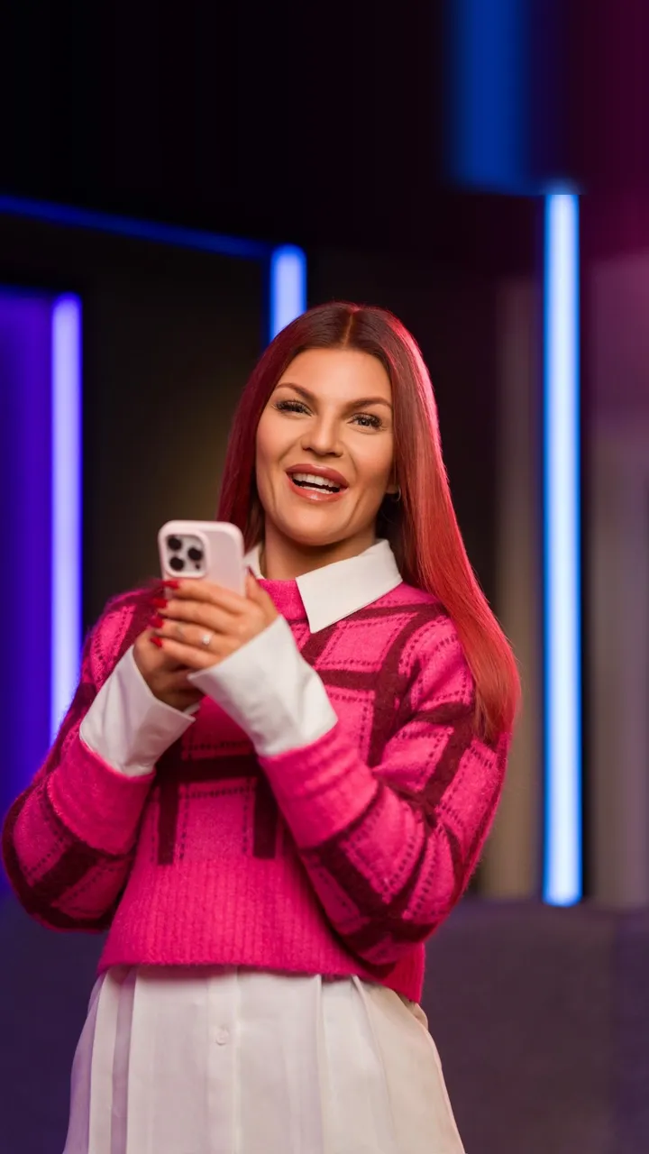 An Adway team member smiling at her phone while scrolling in the Gothenburg office