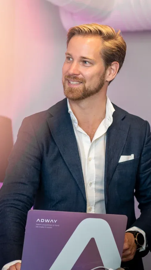 An Adway team member holding a branded Adway laptop at an event